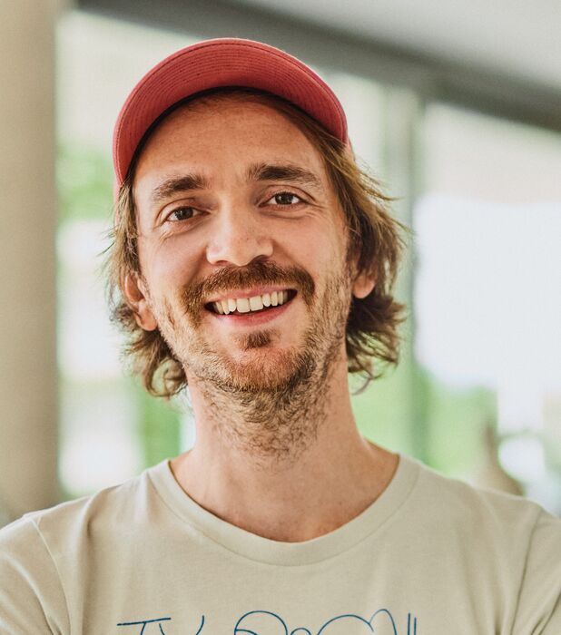 Employee Felix Schittig standing in the office, smiling